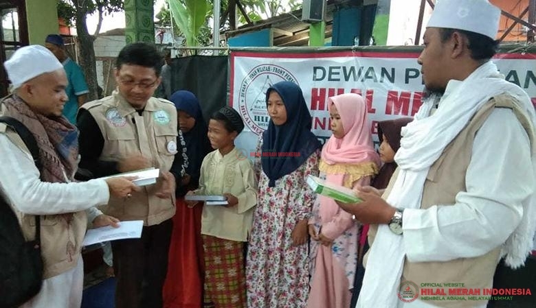 Ustadz Aries Ayyash selaku Ketua HILMI Kota Bekasi (dua dari kiri) saat memberikan santunan.