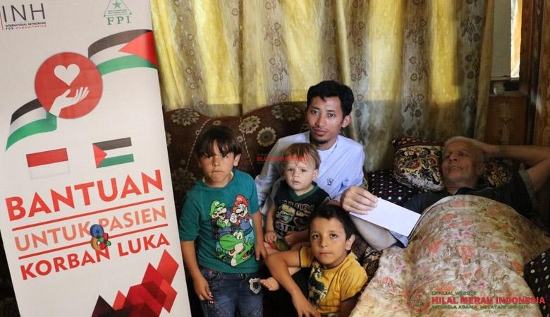 Muhammad Husein (tengah) dari INH saat menyalurkan bantuan HILMI-FPI kepada para korban.
