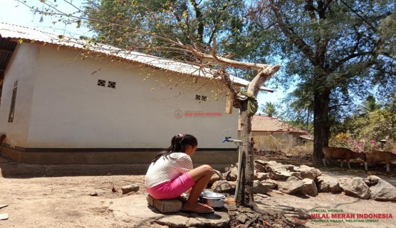 Seorang anak yang sedang mencuci piring dari air yang tersalur di dusun Desantreng, Desa Akar-Akar-Lombok Utara