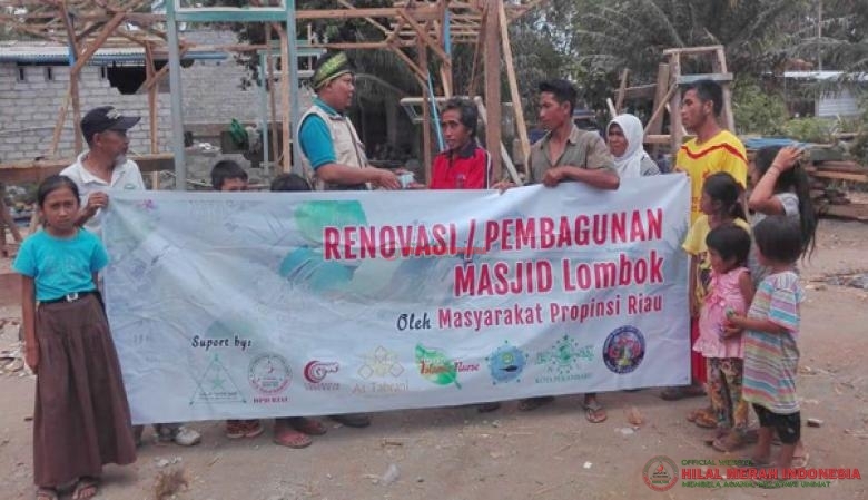 Sekretaris Daerah (sekda) DPD HILMI-FPI Riau, Budi Prazto bersama para warga menyerahkan bantuan material untuk merenovasi Masjid