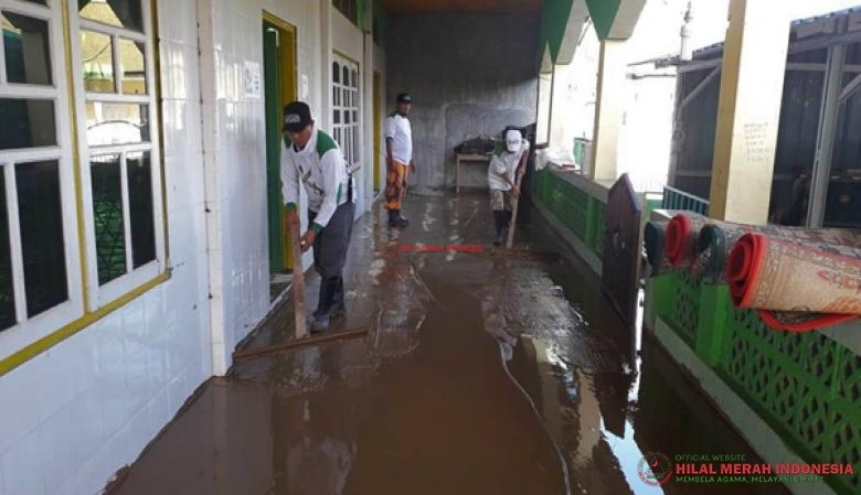 tim relawan HILMI-FPI sedang membersihkan lumpur dan sampah yang menggenang sarana ibadah