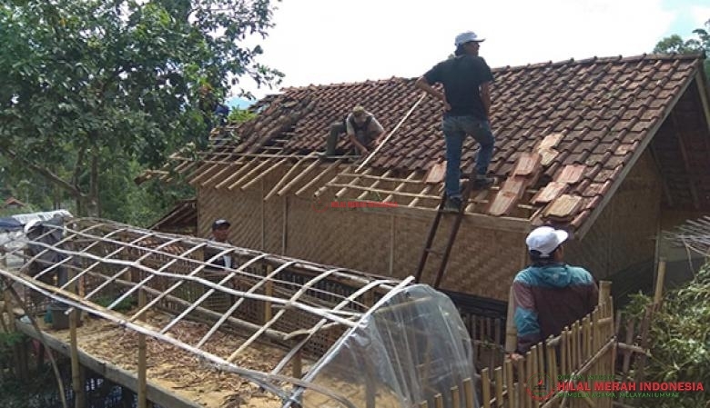 tim relawan HILMI-FPI Garut membersihkan beberapa rumah warga yang rumahnya tertimpa pepohonan yang tumbang akibat angin puting beliung