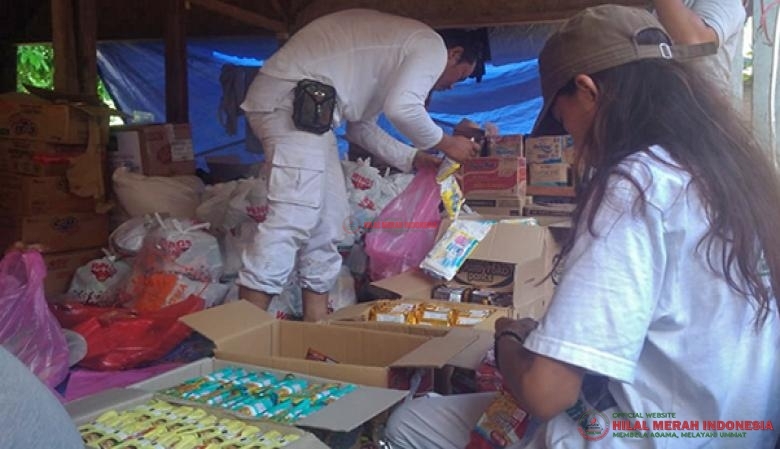 Puluhan relawan HILMI-FPI Nasional menyiapkan paket sembako untuk didistribusikan ke rumah-rumah warga