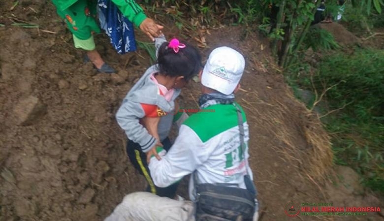 Salah seorang Relawan dari DPW FPI Makassar tengah menggotong anak kecil yang terjebak oleh longsoran tanah
