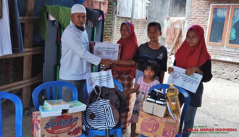 Relawan Hilal Merah Indonesia (HILMI) saat menyerahkan bantuan.