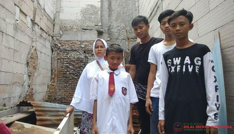 Ibu Mardiana berserta sebagian anaknya, di tengah rumahnya yang sedang dibangun.