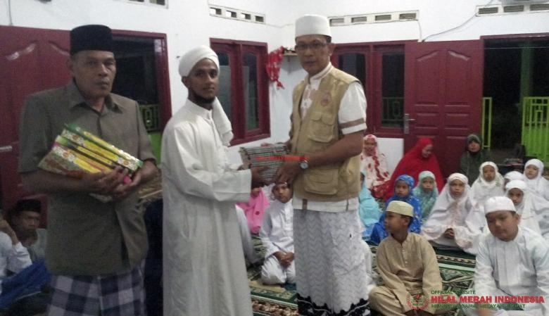 Ketua DPW FPI Langkat, Ustadz Riza Azhari (kanan) saat menyerahkan bantuan Al Quran.