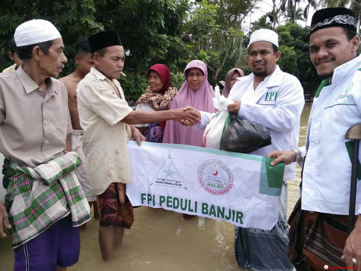 Ketua FPI Aceh, Tengku Muslim At-Tahiry (dua dari kanan) saat memimpin langsung penyerahan bantuan di lokasi musibah banjir Aceh Utara.